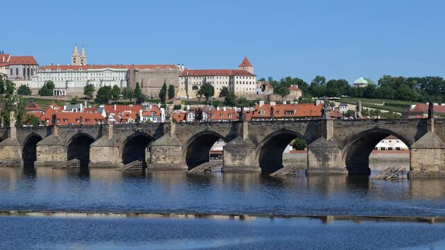 City of Prague at Vltava river in Czechia (Czech Republic). Panning to the left along Charles Bridge and Prague Castle and zoom out to wider skyline.