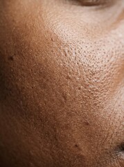 Fototapeta premium Extreme close up of healthy dark skin texture showing natural pores and complexion.