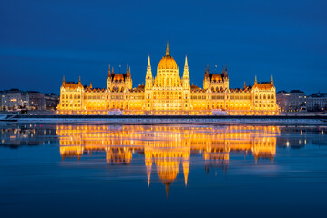 Fototapeta premium Close-up of the illuminated Hungarian Parliament Building perfectly reflected in the Danube river at night, Budapest