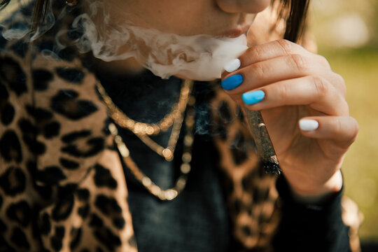 Woman smoking marijuana cigarette outdoors