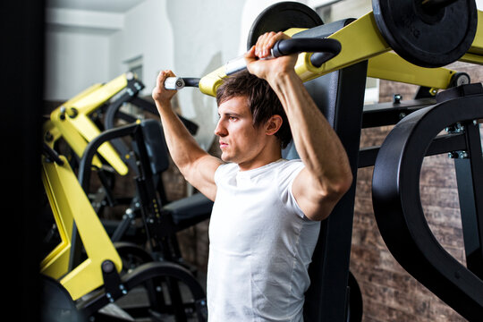 Austria, Klagenfurt, Man in fitness center doing machine workout