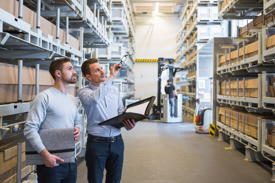 Two men talking in factory warehouse