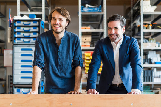 Portrait of smiling businessman and employee in factory