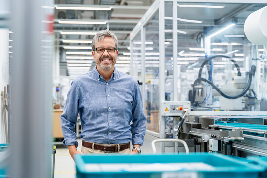 Engineer standing in modern factory with automation machinery