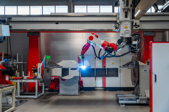 Automated industrial robot welding metal in factory