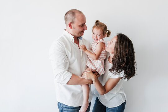Happy family standing in front oft white background