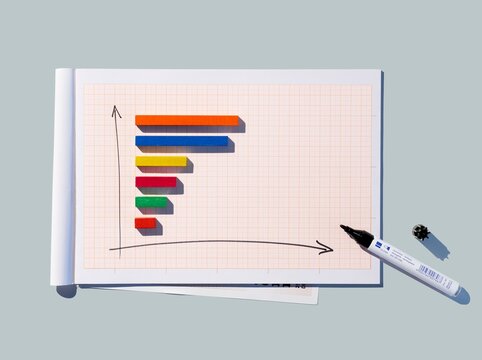 Multicolored 3D bar chart on graph paper representing progress