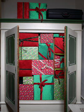Open wardrobe filled with wrapped Christmas presents indoors