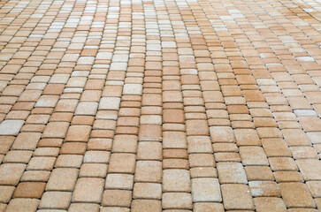 Fototapeta premium Close-up texture of beige concrete paving stones. Interlocking paving blocks laid in a decorative pattern for sidewalks, patios, driveways and landscape design.