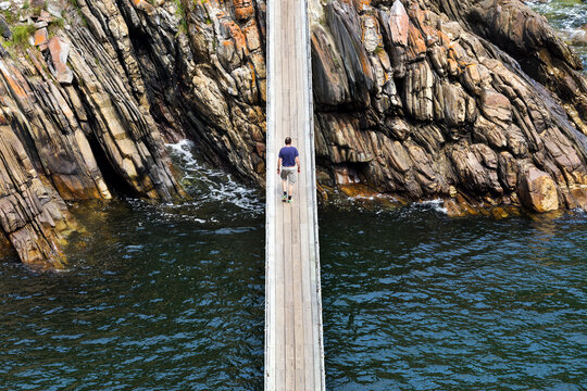 Africa, South Africa, Western Cape, Paarl, Garden Route National Park, Tsitsikamma National Park, man walking on wooden bridge