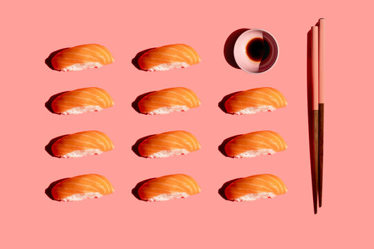 Studio shot of chopsticks, bowl of soy sauce and salmon nigirizushi pieces