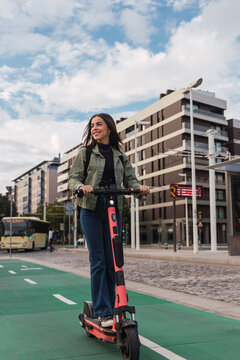 Woman riding electric push scooter in city
