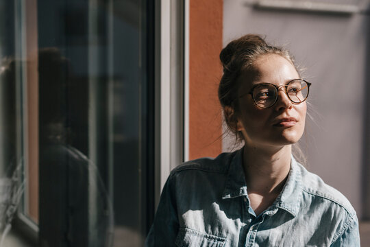 Young woman with glasses thinking