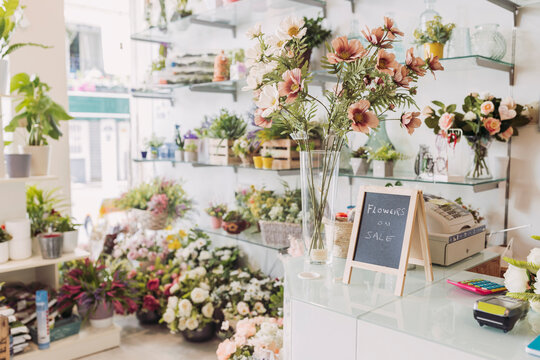 Sign board kept by flower vase at checkout in flower shop