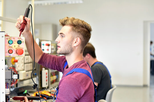 Electrician students looking at device