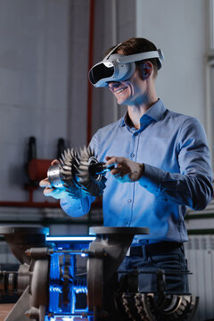 Caucasian young male engineer using vr headset for mechanical design testing in laboratory, blue light