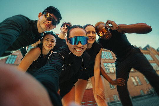 Running friends taking a group selfie before outdoor fitness club meet up