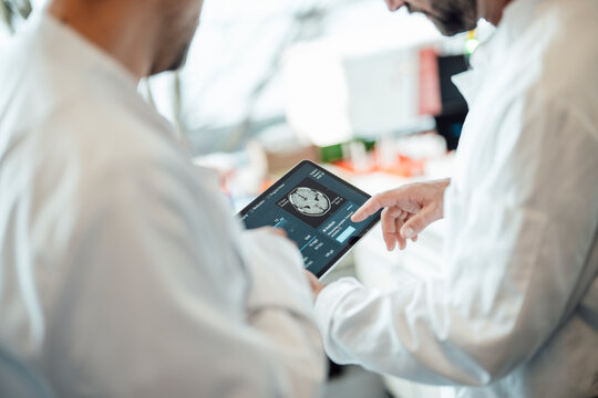 Medical team analyzing brain scan on tablet in laboratory