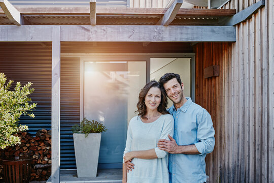 Couple standing in front of door of their home