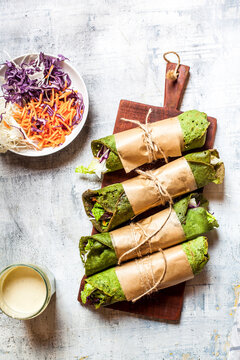 Lettuce wraps with spinach tortillas filled with lettuce, carrots and salad dressing