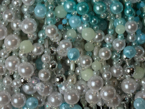 multicolored beads, colored pearl beads in white and blue tones, textured background