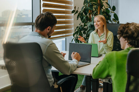 Team discussion at office desk with businesswoman and colleagues