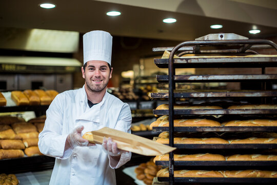Baker in supermarket packing fresh braed