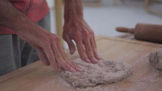 Hands shaping pizza dough by hand, homemade cooking, Italy