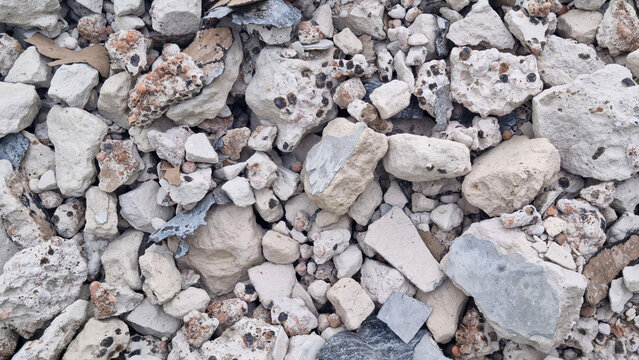 Broken concrete rubble, cement chunks, aggregate stones and construction debris pile