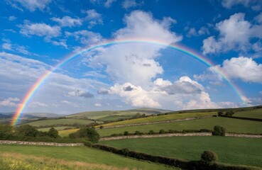 Fototapeta premium Rainbow arch over green countryside landscape