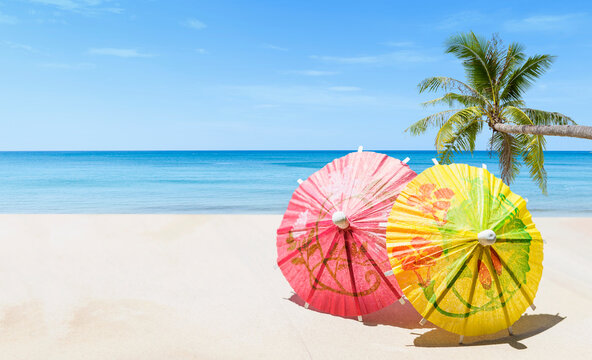 Colourful paper umbrella on tropical beach background, summer season concept, outdoor day light