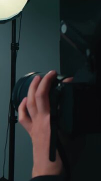 Photo shoot in a professional photography studio. Female model posing as the photographer takes photos with a flash. Time lapse