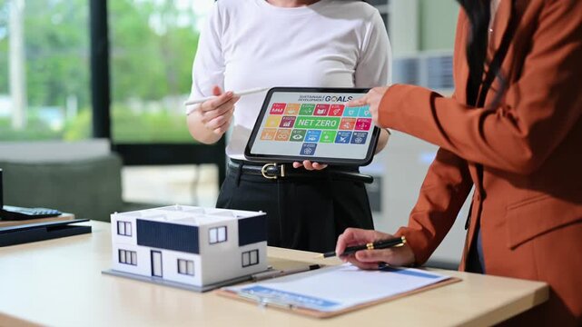 Business professionals reviewing ESG dashboard data and sustainable real estate strategies using digital analytics and corporate performance metrics.