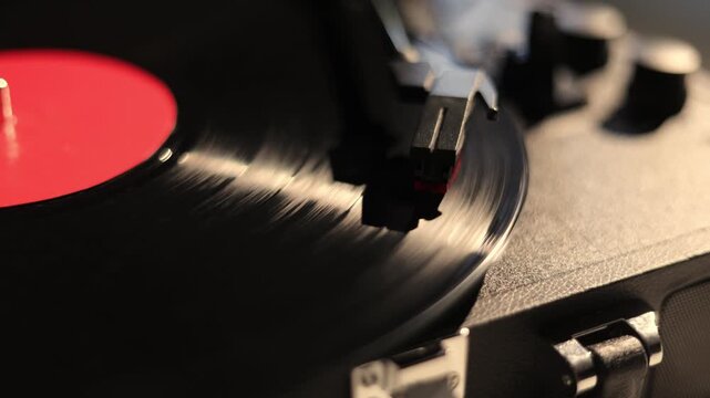 Close-up of a spinning vinyl record on a turntable with a red label