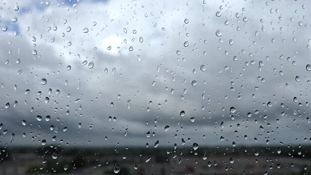 Drops of the rain sliding down slowly on window glass, rainstorm, rainy season,