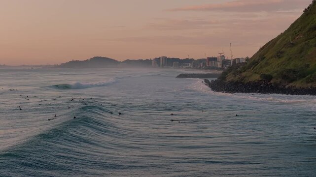 Surfers On The Wavy Sea By Burleigh Heads At Sunrise In Australia. - aerial shot