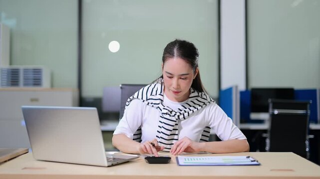 Business woman using tablet and laptop for doing math finance on an office desk, tax, report