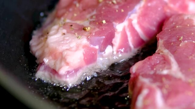 video set of a man cooking steaks in a frying pan, Chef cook sets stewpan meat steak on frying pan. Making delicious dishes process. Restaurant with gourmet cuisine. Public catering concept.