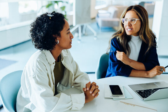 Two women discuss a project in a professional office