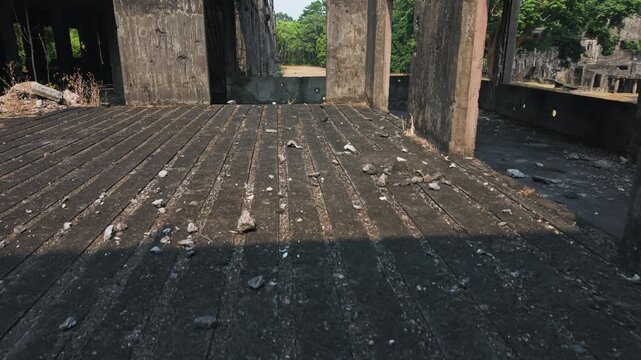 Slow drone ascent crumbling WWII barracks on Corregidor Island, Philippines, war documentaries, history and memorial landmark.