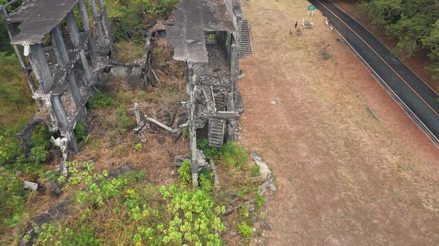 Slow drone descent crumbling WWII barracks on Corregidor Island, Philippines, history and memorial landmark.