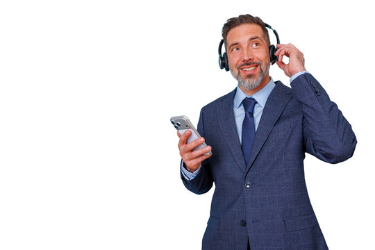 Happy businessman holding smartphone and listening to music or podcast in headphones, enjoying audio content