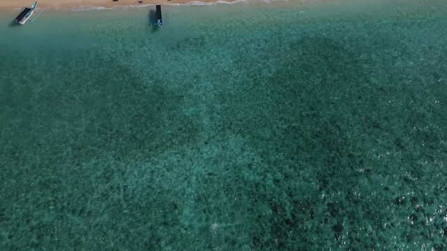 Aerial Tilt Up View of the Crystal Clear Blue Waters of Tabuhan Island, East Java