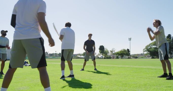 Playing frisbee diverse male friends tossing yellow disc on grass field, sports gear pile