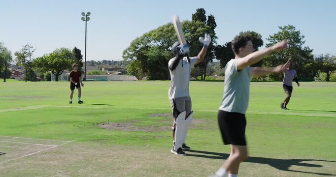 Bowler entering crease bowling on pitch batsman hitting as umpire signaling him taking guard