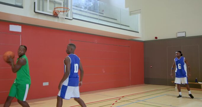 Receiving pass under shot clock, african american player dribbling ball, taking shot in school gym