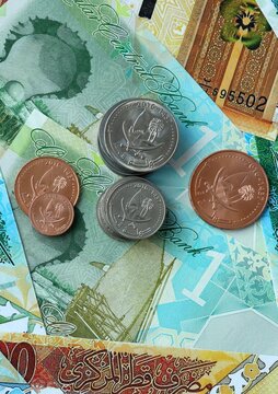 Qatari riyal money bills and coins in pile. Big amount of Qatar QAR currency cash close up