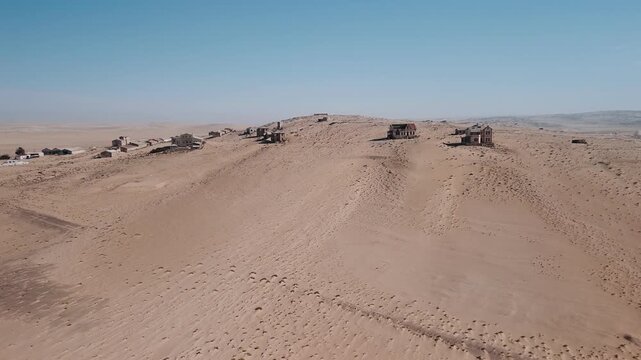 Aerial view of kolmanskop ghost town in namibia swallowed by the arid namib desert sands under a clear blue sky