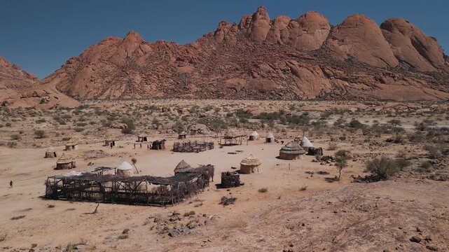 Traditional himba village aerial view with huts and kraal near spitzkoppe mountains in the namib desert, namibia