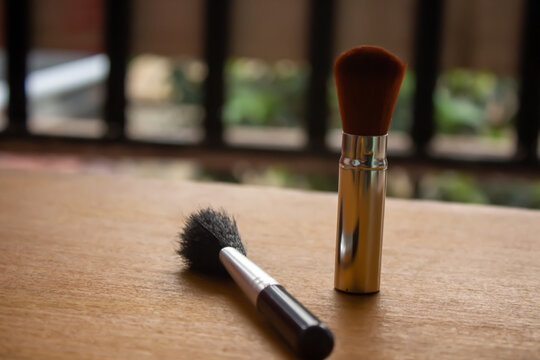 Makeup Brushes on Wooden Table with Soft Bokeh Background and Copy Space